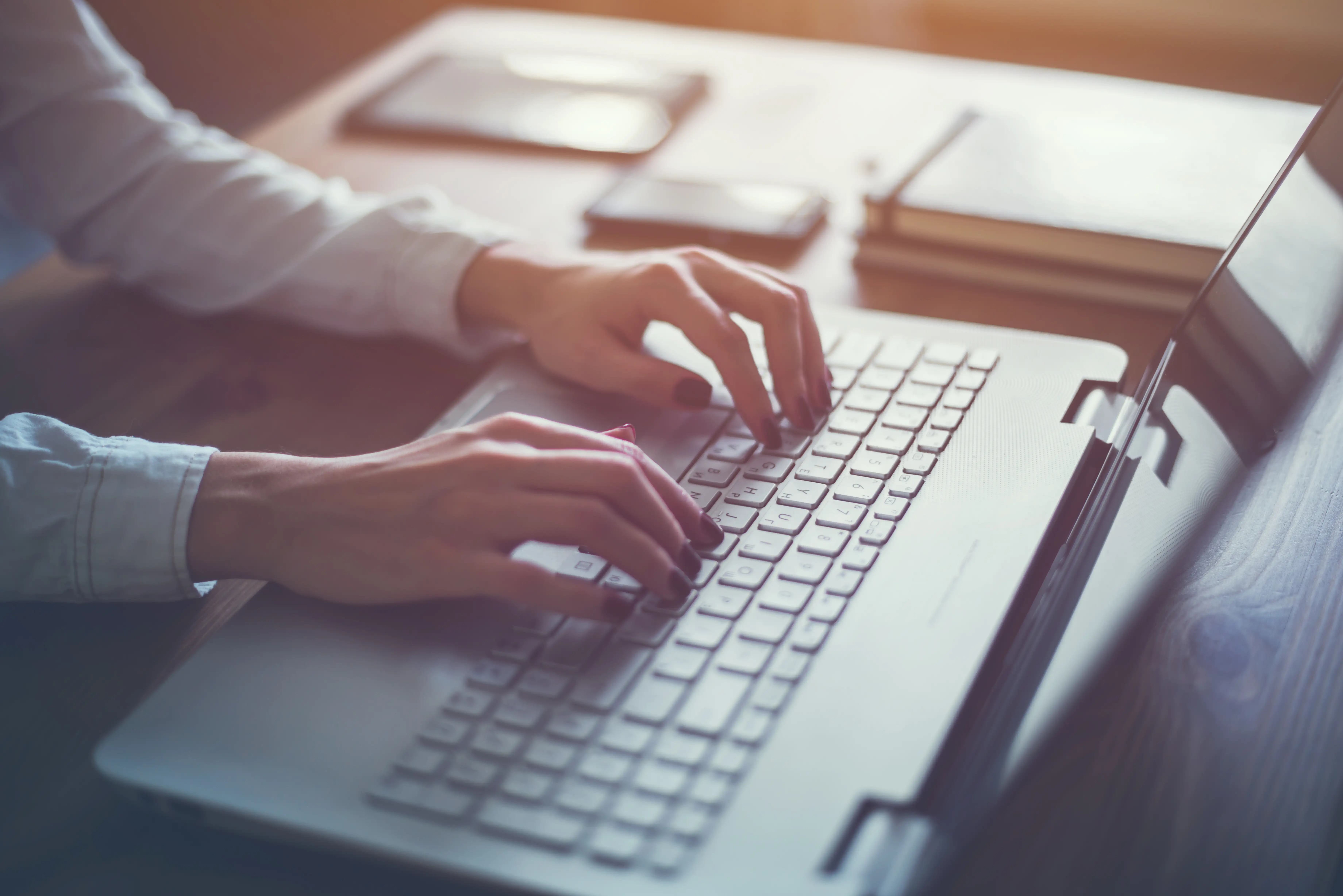 Hands typing on laptop